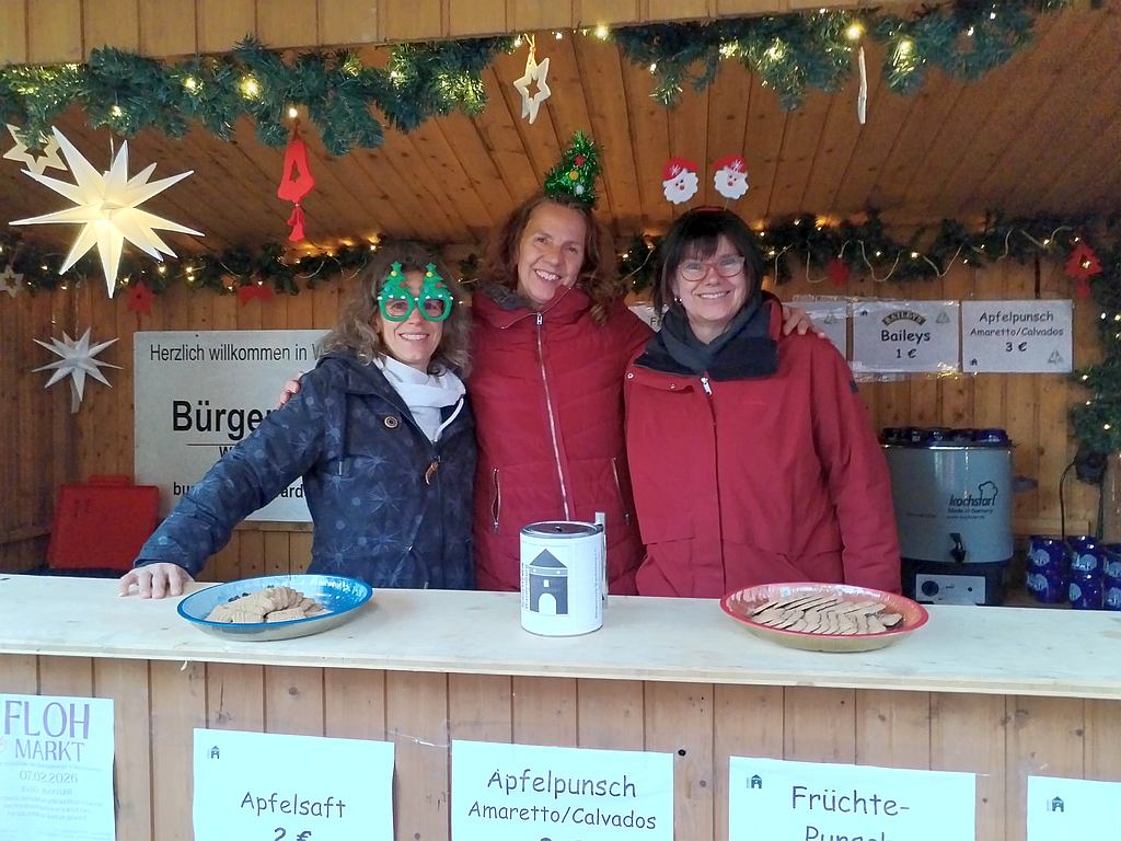 Viel Spaß hatten die ehrenamtlich Tätigen vom Bürgerverein Wardenburg am Stand beim Weihnachtsmarkt 2025 rund um den Wardenburger Glockentur. Foto: Uta Grundmann-Abonyi Agentur GrAbo www.landkreis-kurier.de buergerverein_wardenburg_weihnachtsmarkt_foto_grabo_2025